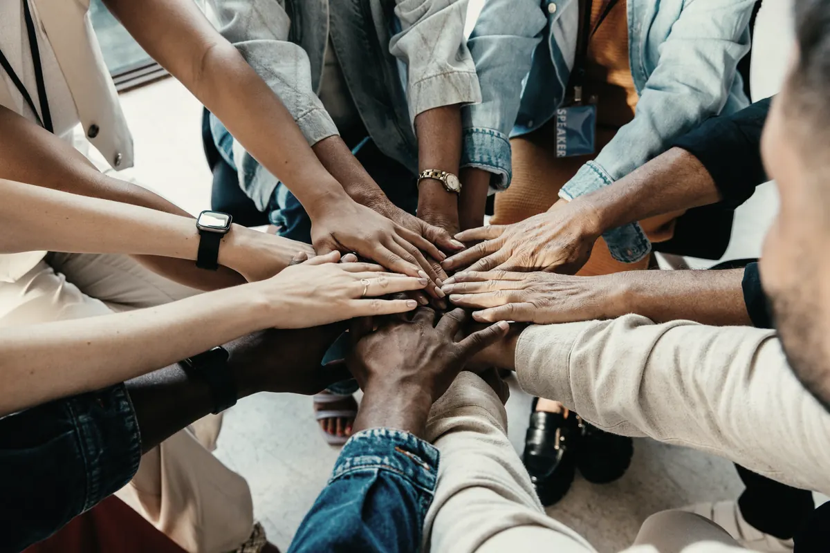 Un equipo junta sus manos